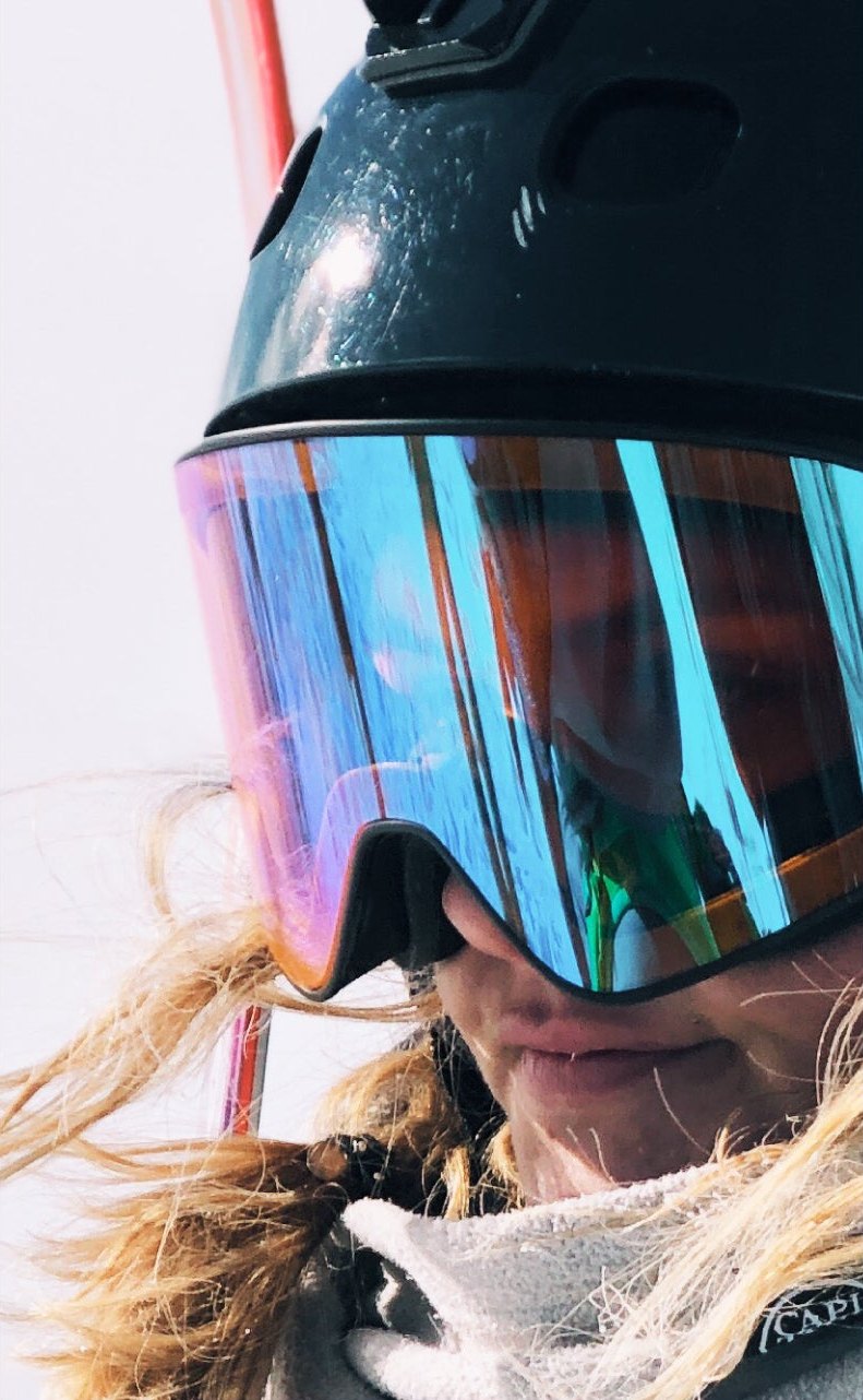 Nahaufnahme einer verspiegelten Skibrille von Vertical Unit; im Glas schimmert das Licht in Pink und Türkis